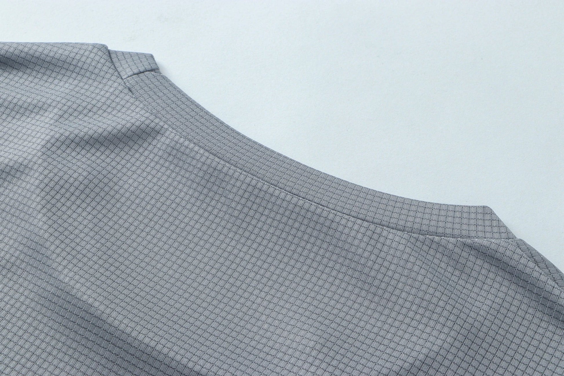 Detail shot of gray fabric with smooth finish and curved edge.