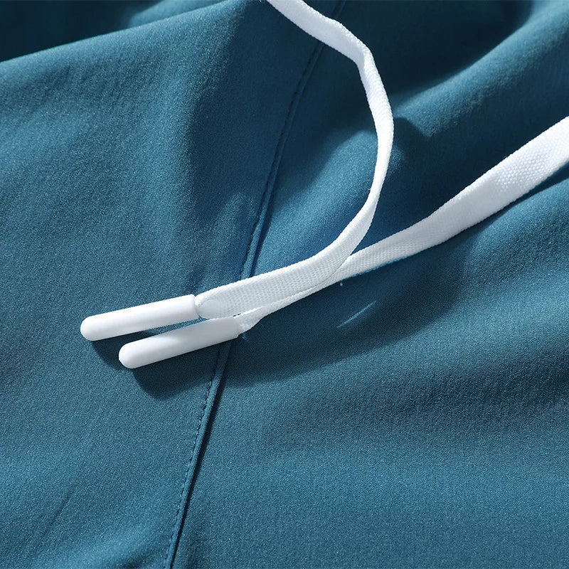 Detail view of teal running shorts showcasing drawstring and smooth fabric.