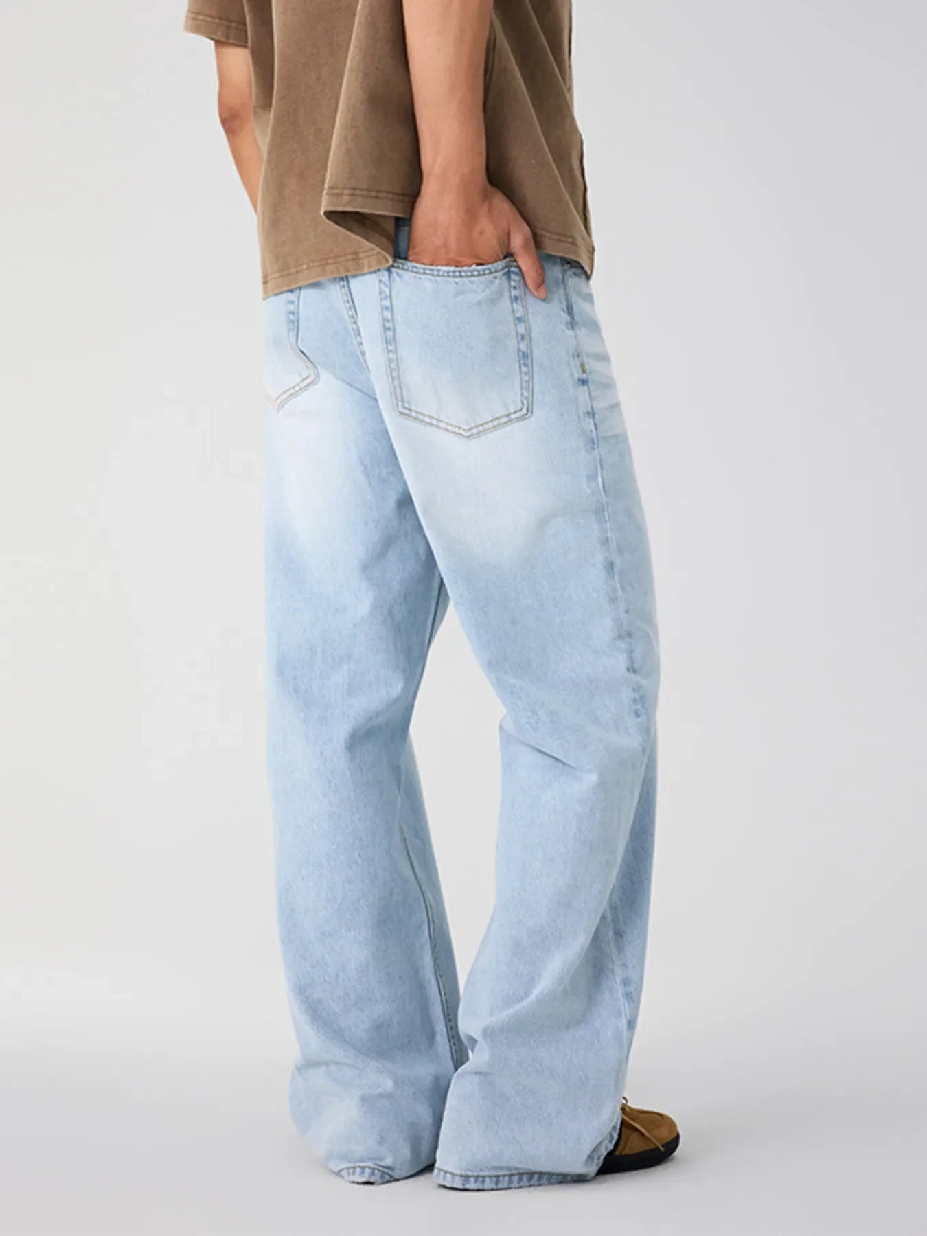 Detail close-up of light blue wide leg jeans highlighting the faded wash.