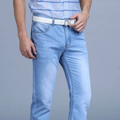 Detail close-up of blue slim jeans with a belted design.