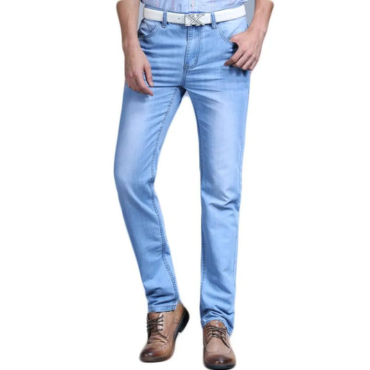 Front view of light blue slim jeans with distressed details.