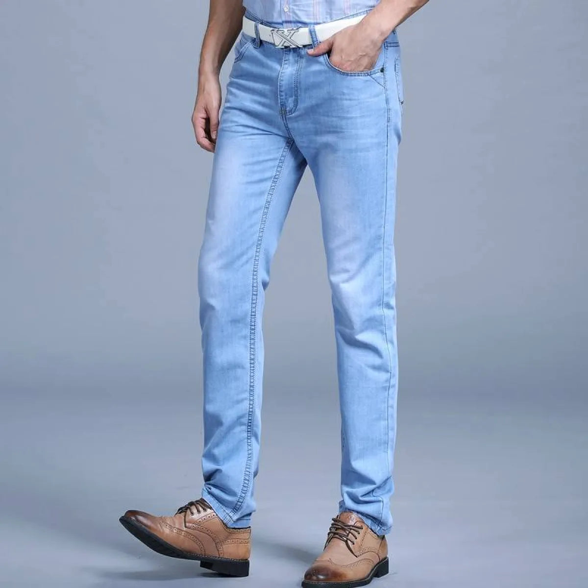 Lifestyle shot of blue slim jeans in a casual setting.
