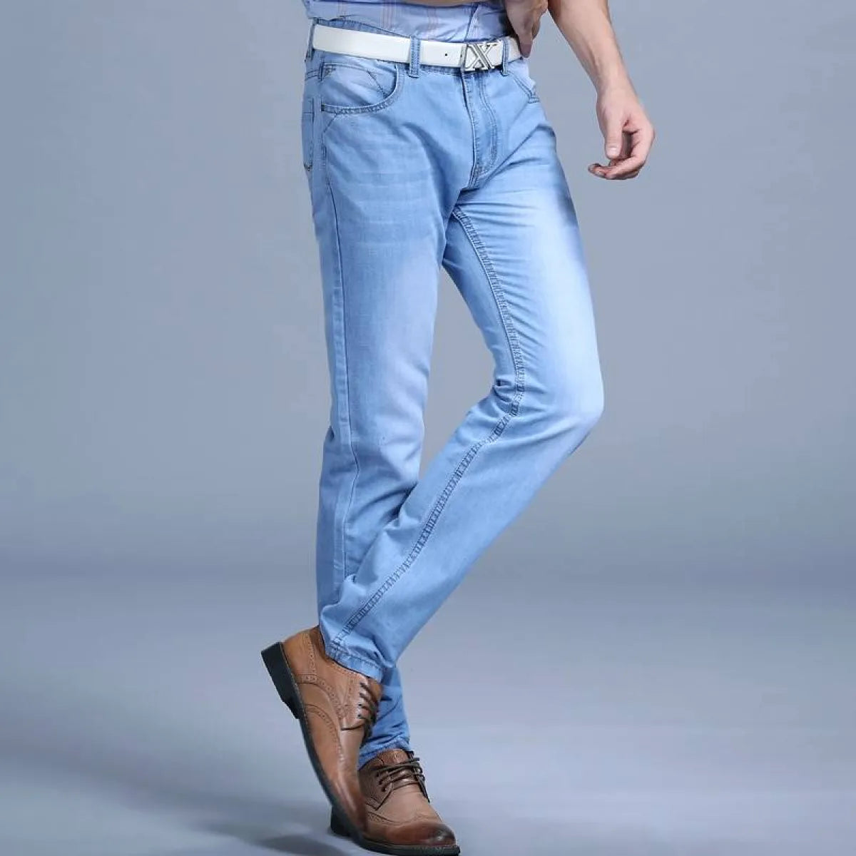 Side view of light blue slim jeans with distressed details.