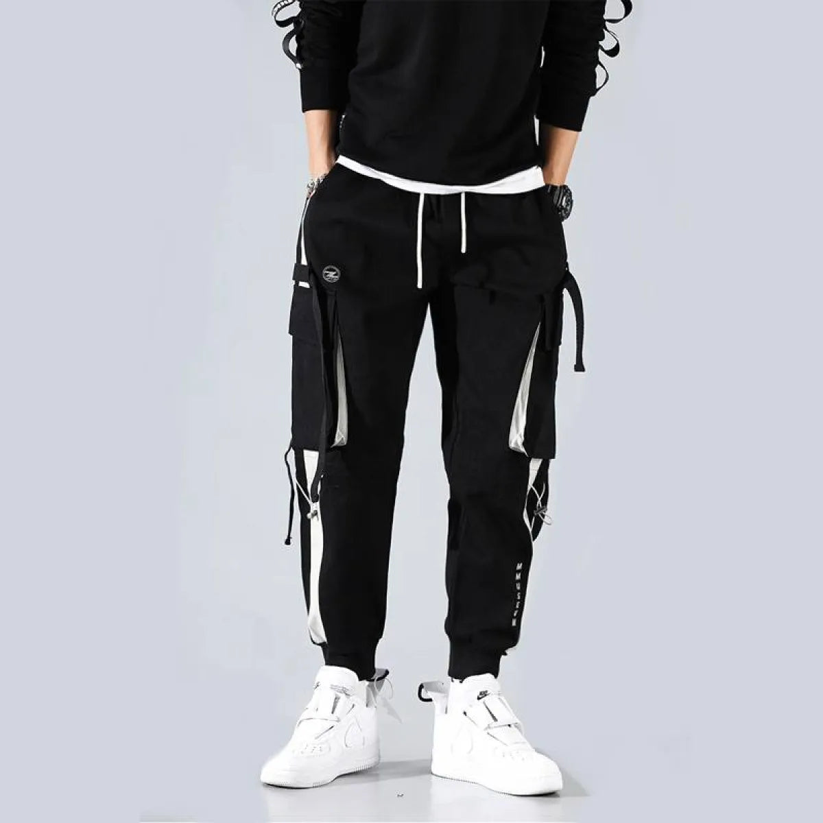 Black cargo pants with cargo pockets and drawstring waist, side view.