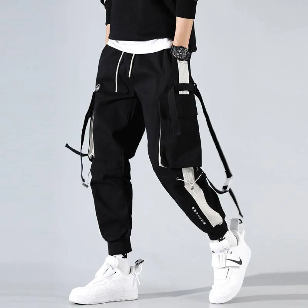 Black cargo pants with cargo pockets and drawstring waist, side view.