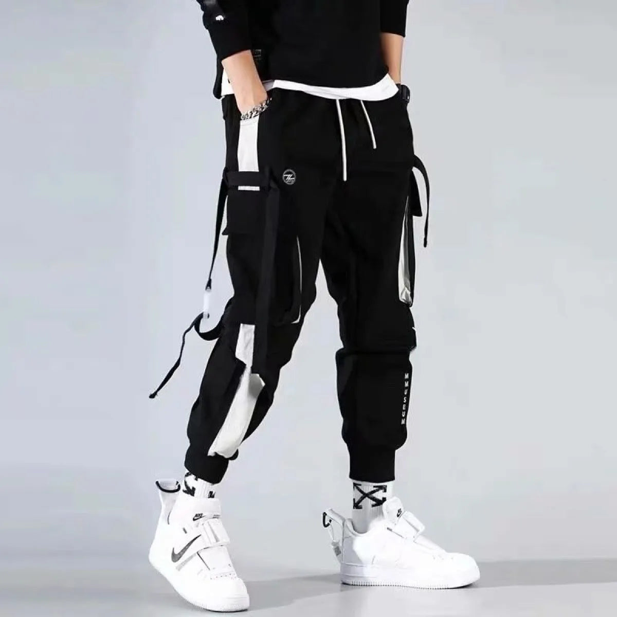 Black cargo pants with straps and elastic cuffs, front view.