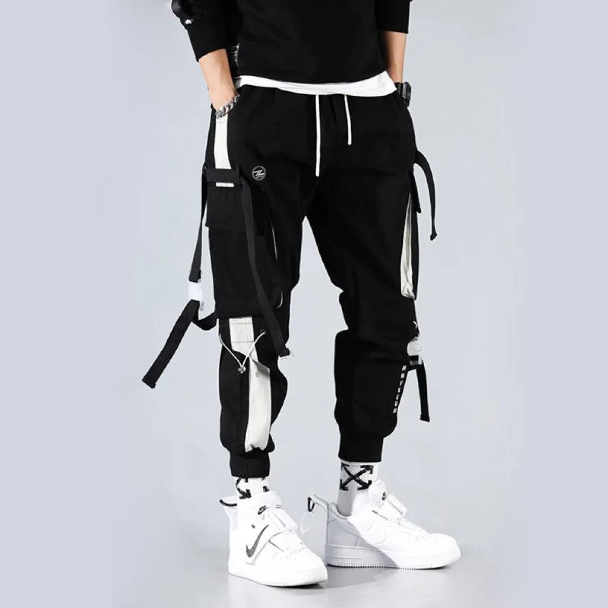 Black cargo pants featuring cargo pockets and straps, side view.