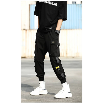 Black cargo pants featuring multiple pockets, side view in urban setting.