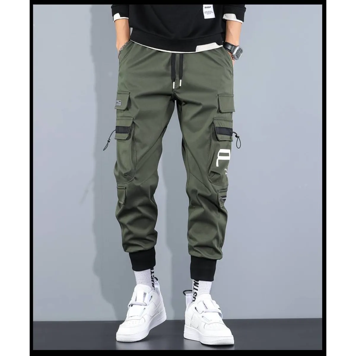 Front view of green cargo pants with cargo pockets and elastic cuffs.