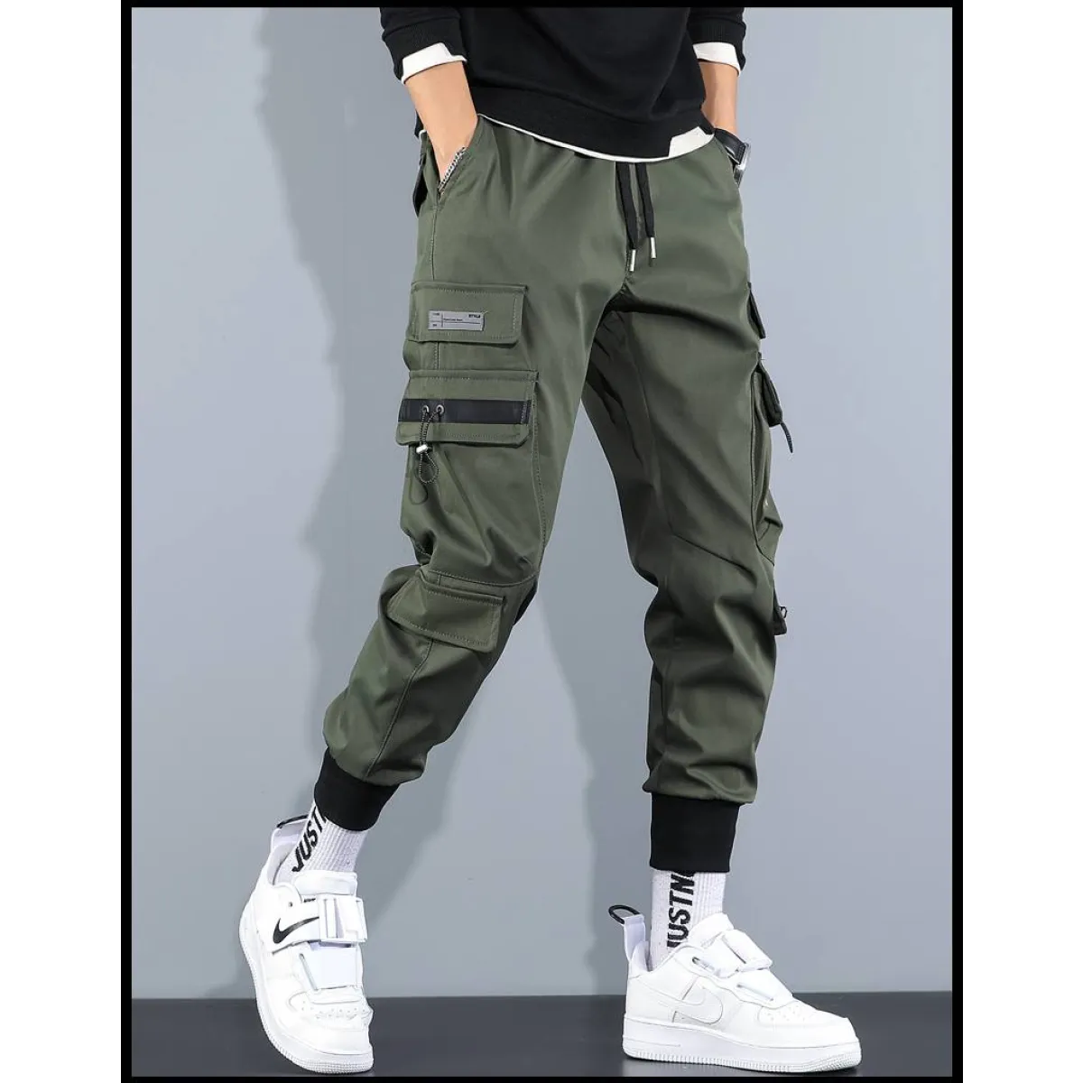 Side view of olive cargo pants with multiple pockets and elastic cuffs.