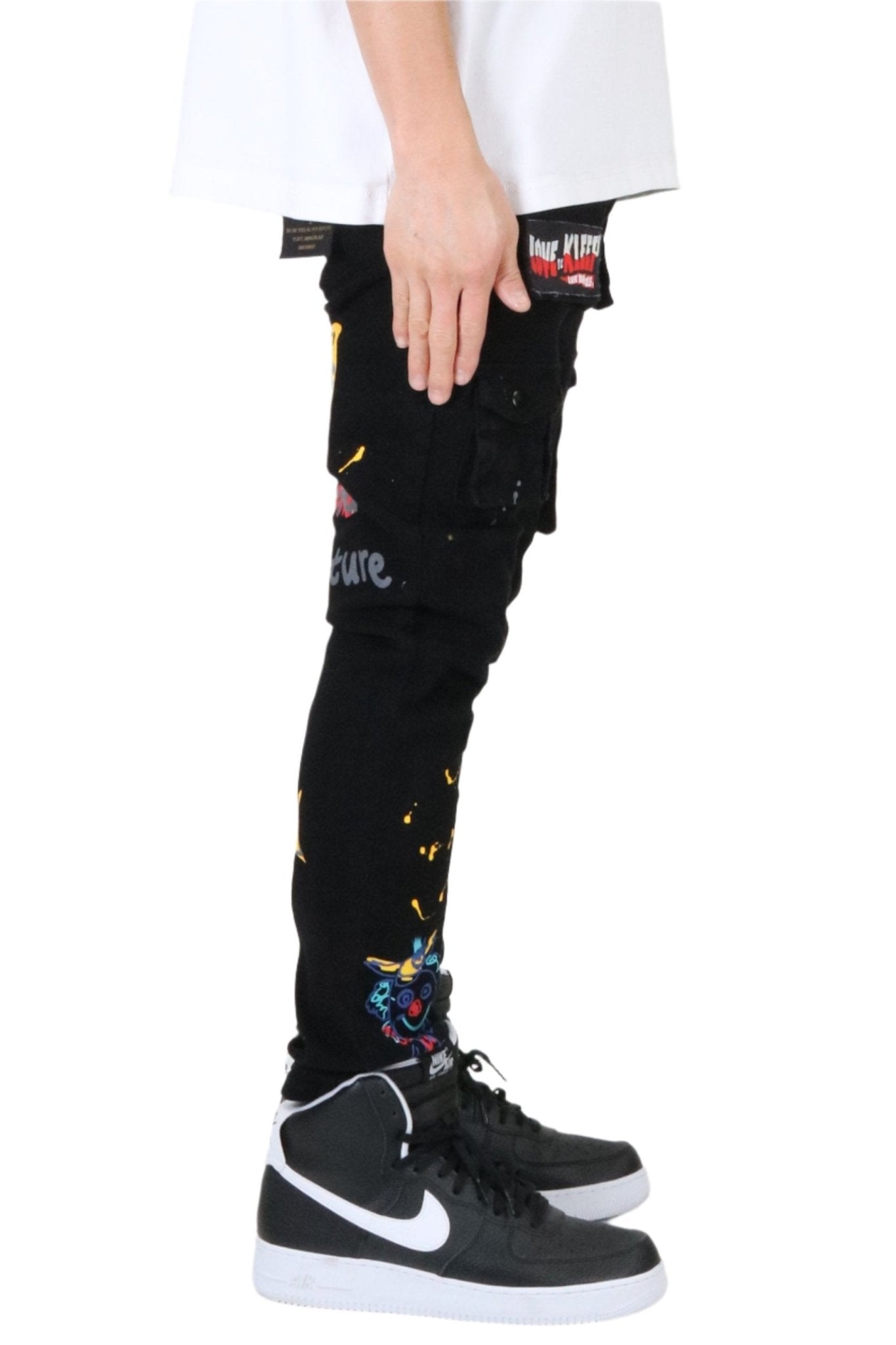 Back view of the black cargo pants with distressed details and graphic patches.