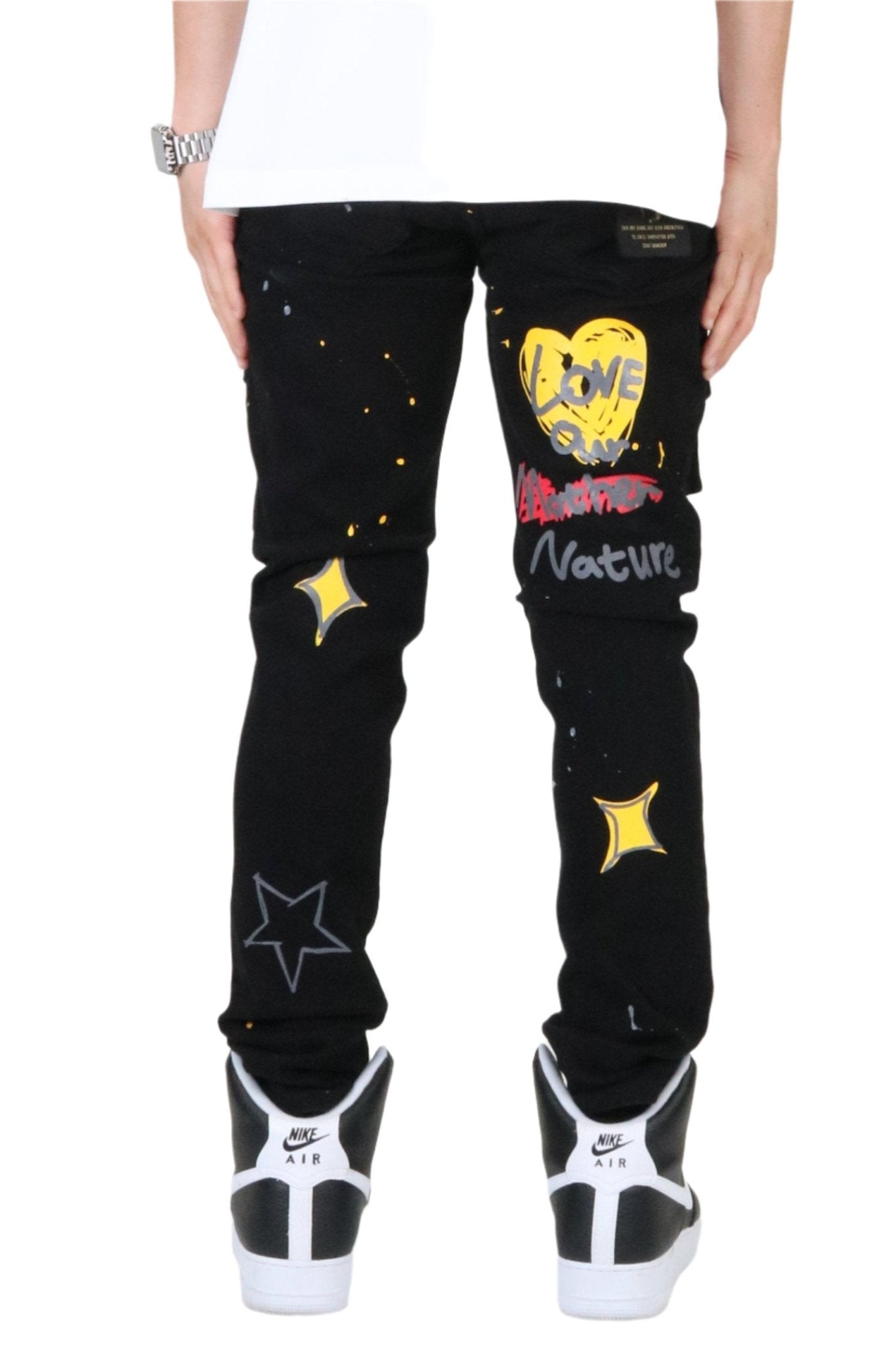 Side view of the black skinny cargo pants showcasing slim fit and graphic patches.