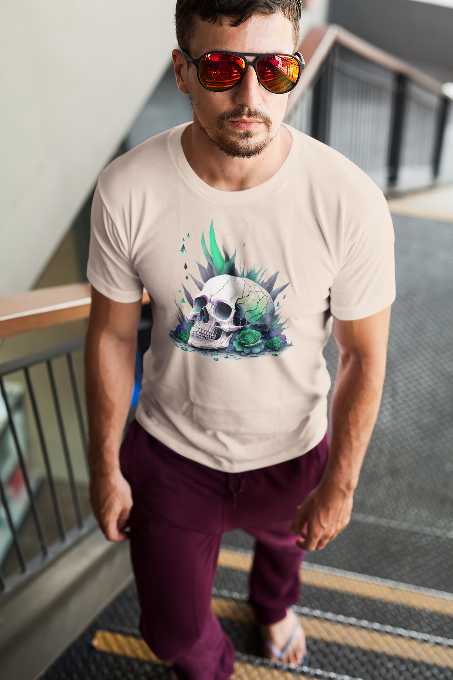 Fitted neon skull graphic tee in beige and green, lifestyle shot of a man going upstairs.