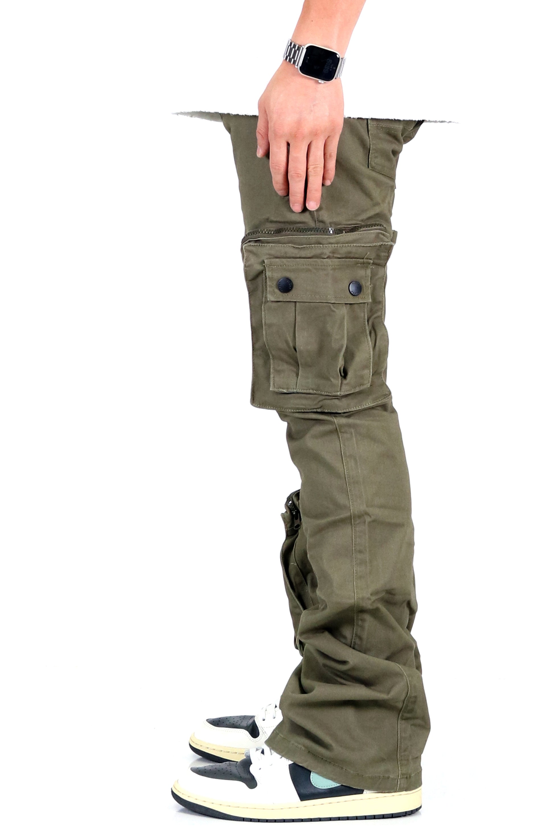 Side view of olive cargo pants with hand inside pocket and cargo style.