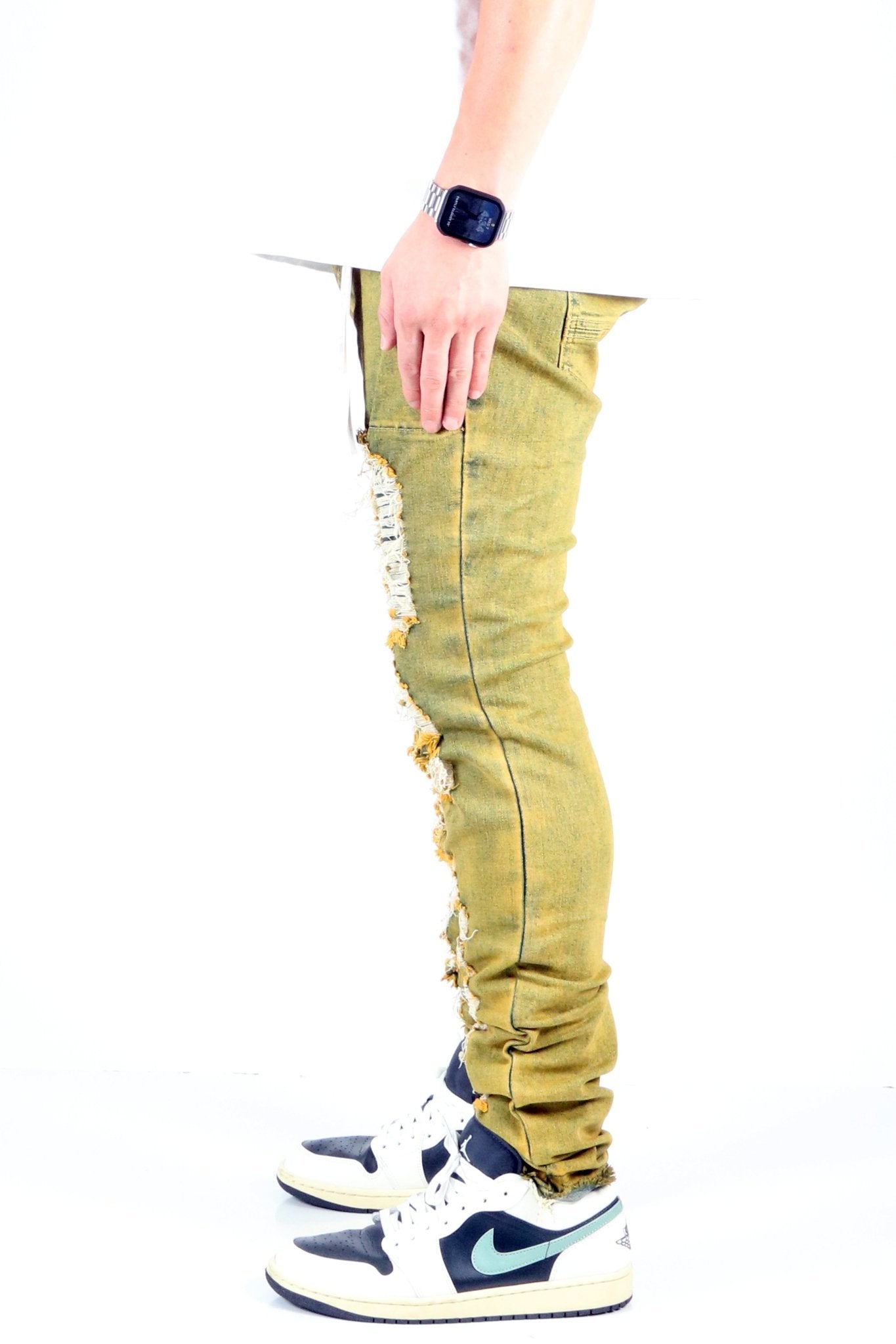 Side view of the vintage olive skinny denim pants highlighting the slim fit.