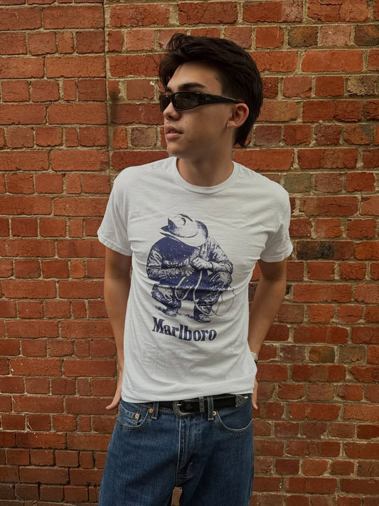 Lifestyle shot of a man in a graphic white t-shirt outdoors.