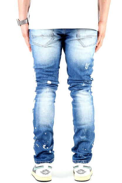 Back view of blue distressed skinny jeans featuring faded areas.