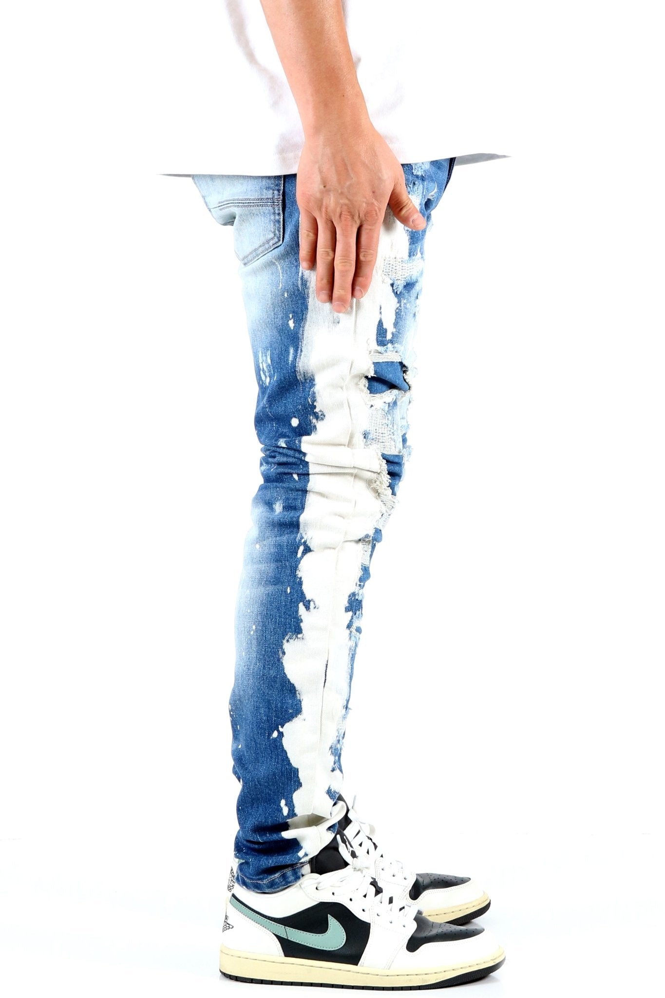 Back view of blue distressed skinny jeans highlighting faded areas.