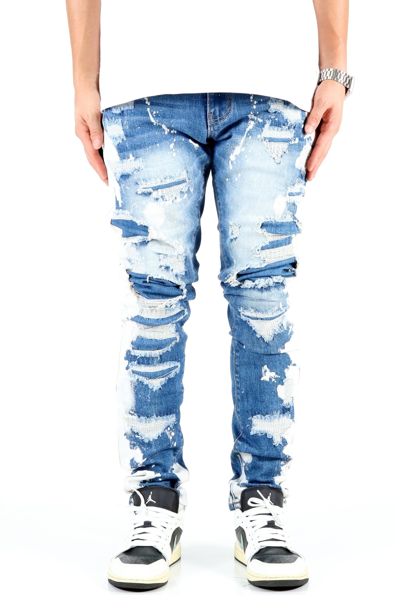 Front view of blue distressed skinny jeans with ripped details.