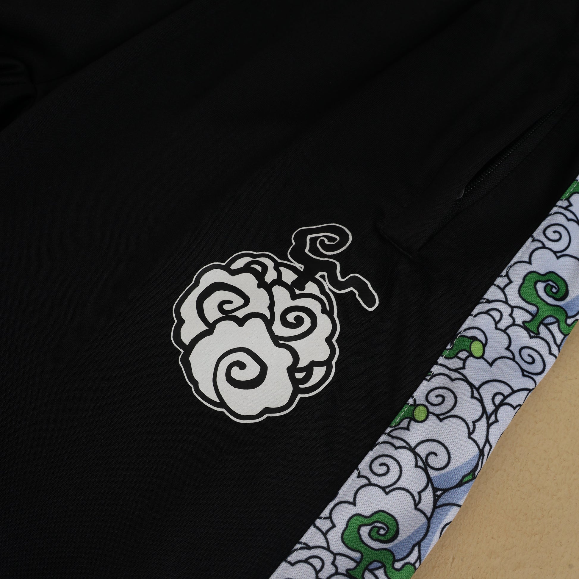 Front view of black jogger pants showcasing side stripes and logo in a studio setting.