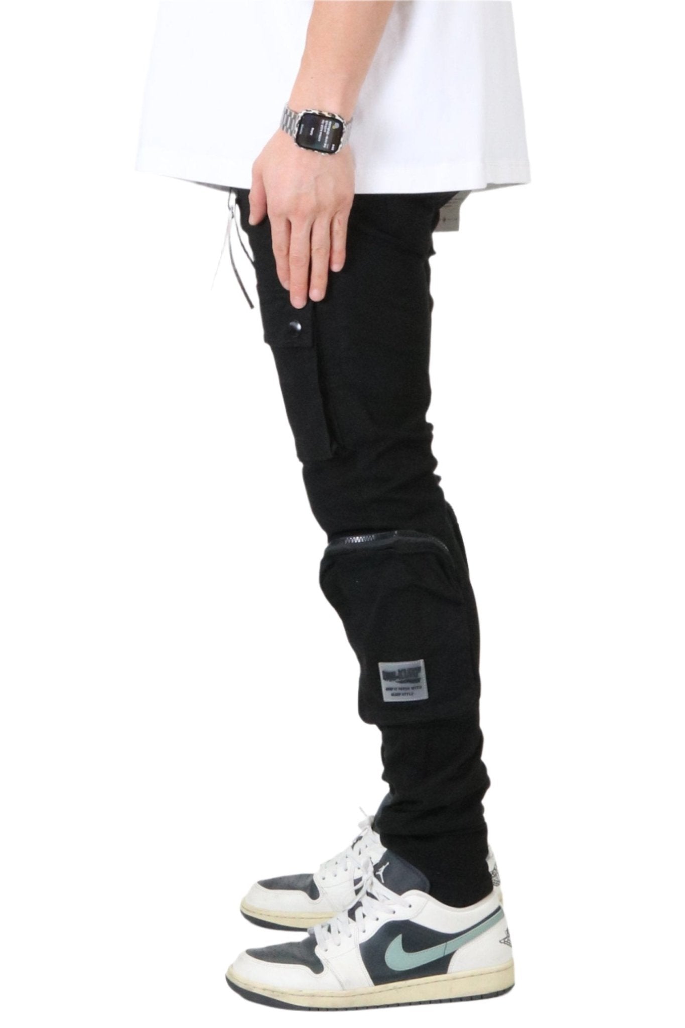 Side view of the black cargo pants showing slim fit and knee detail.