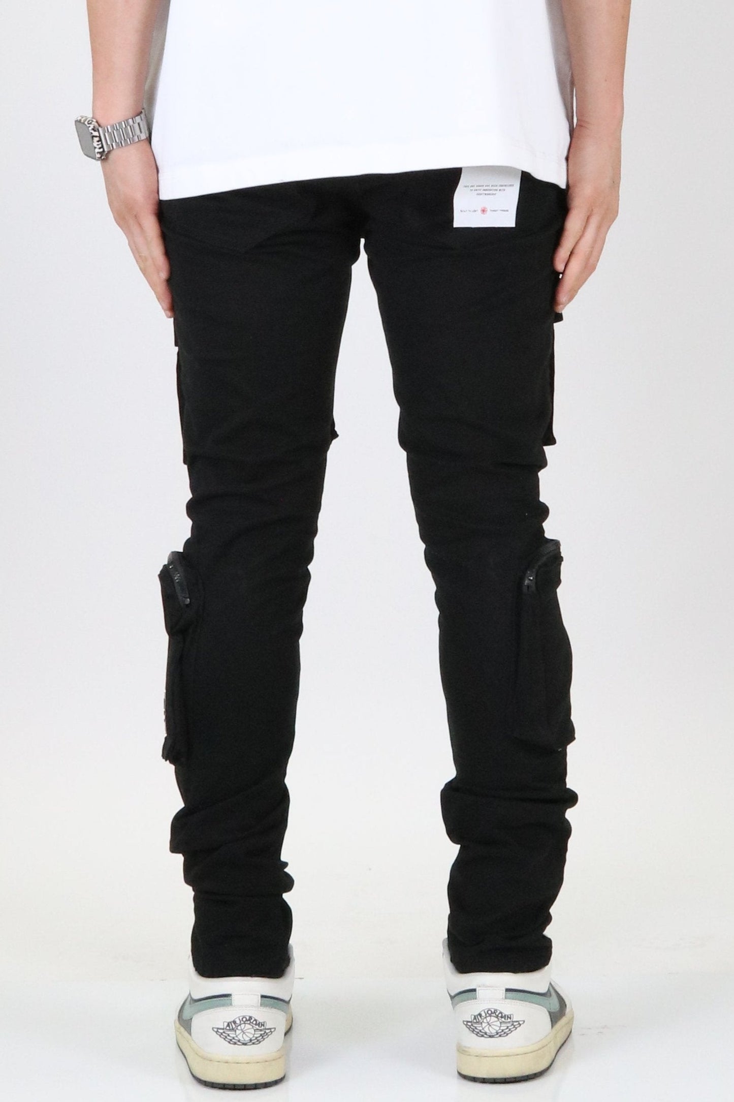 Side view of the black cargo pants highlighting slim fit and knee detail.