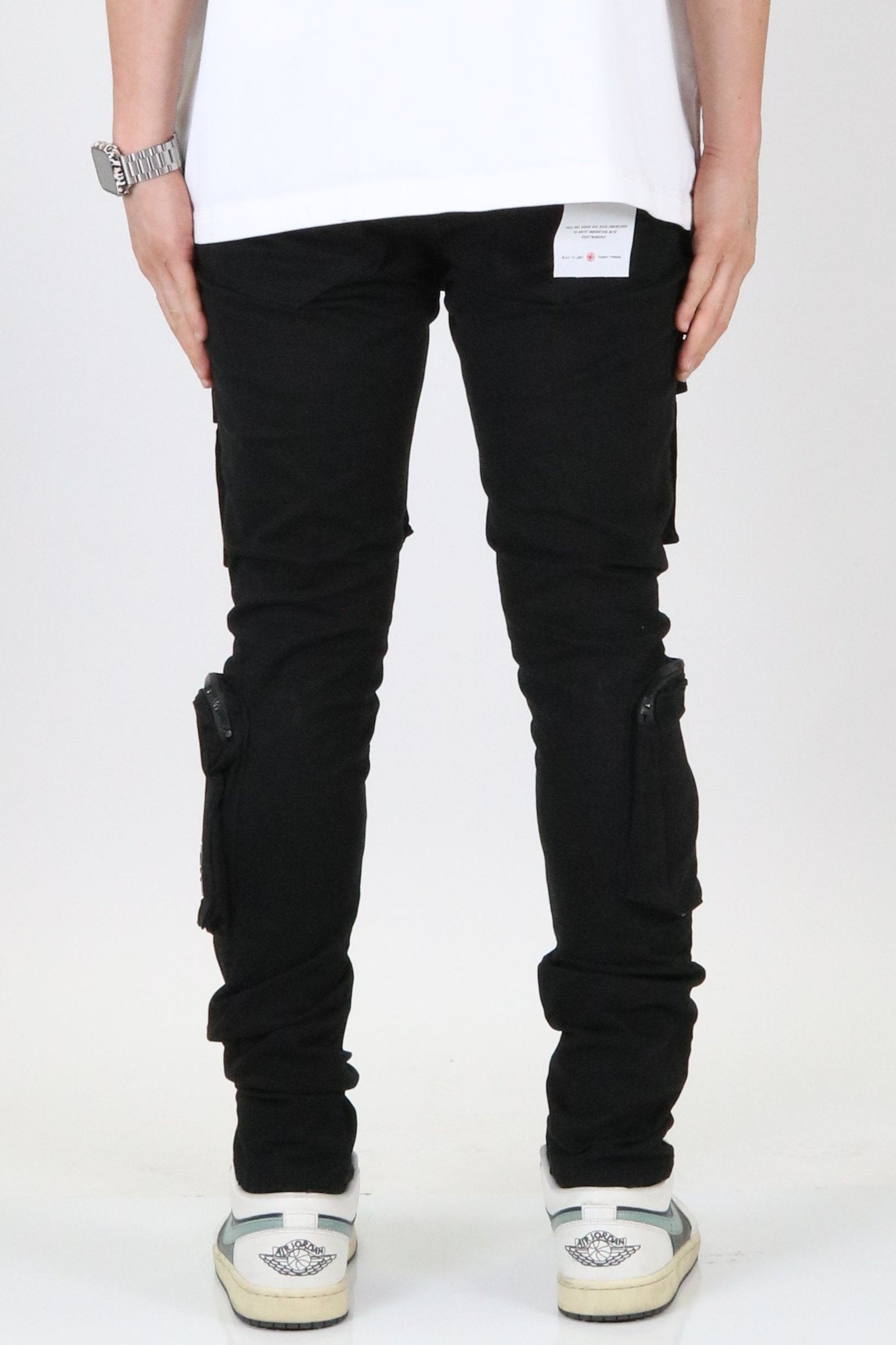 Side view of the black cargo pants highlighting slim fit and knee detail.