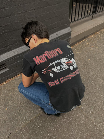 Back view of a man crouching in a black graphic t-shirt.