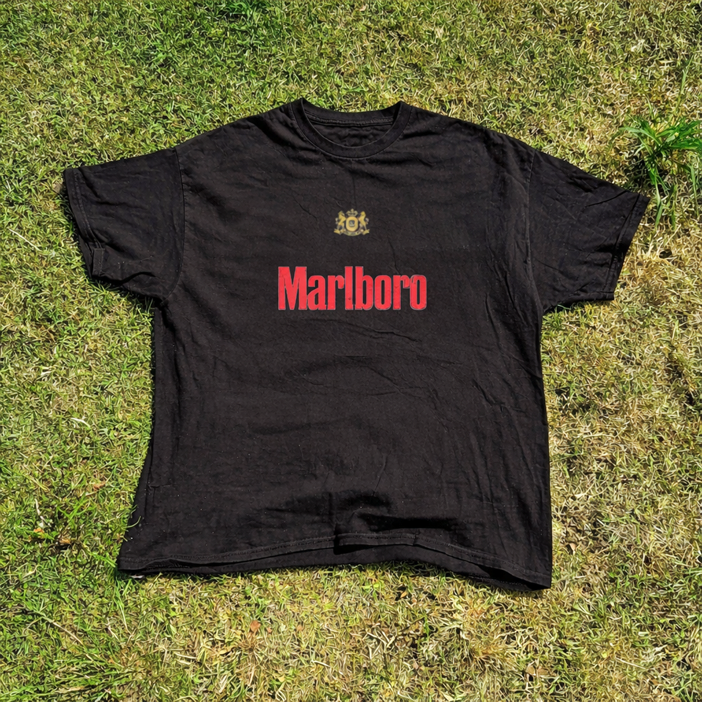 Front view of a black t-shirt with text print and a plain design.