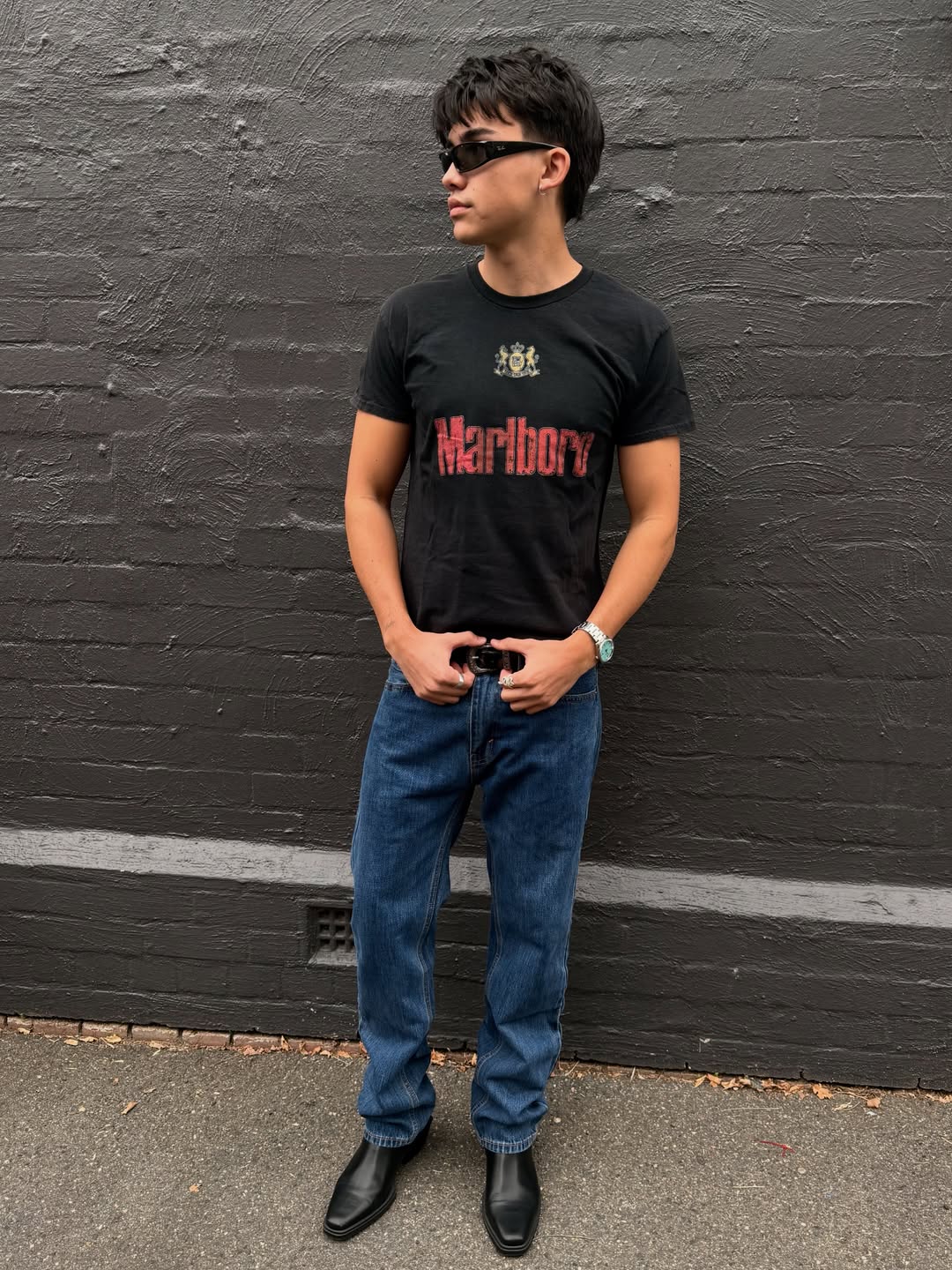 Lifestyle shot of a man in a black graphic t-shirt and jeans.