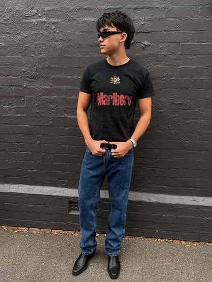Lifestyle shot of a man in a black graphic t-shirt and jeans.