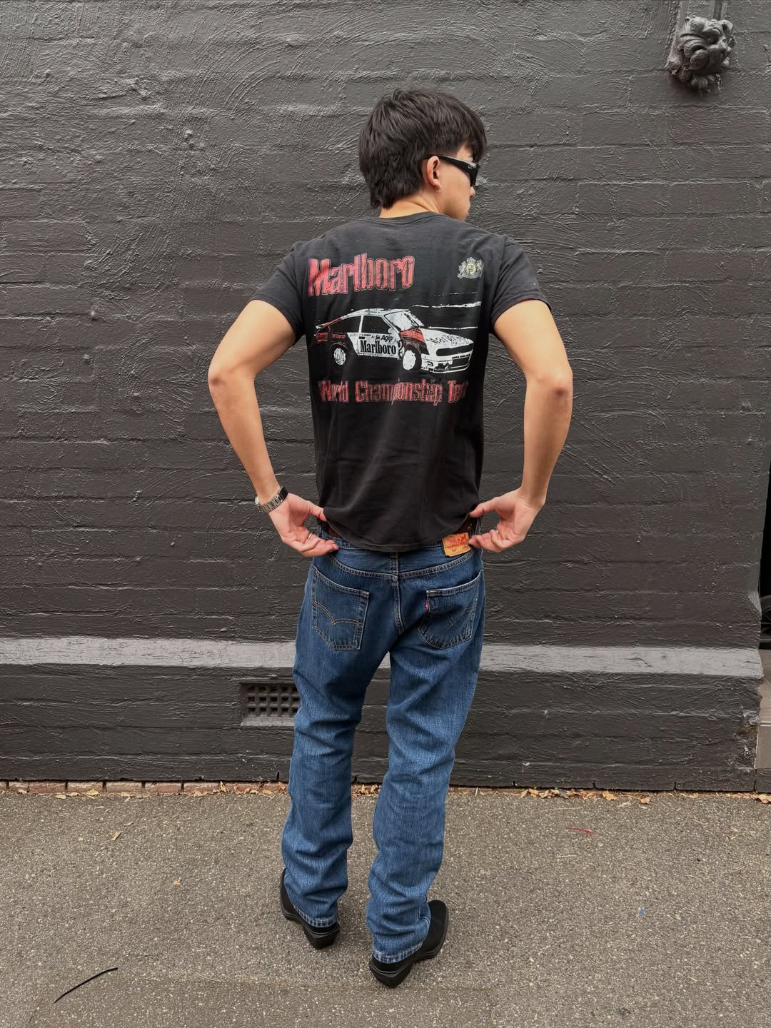 Lifestyle shot of a man in a black graphic t-shirt and jeans.