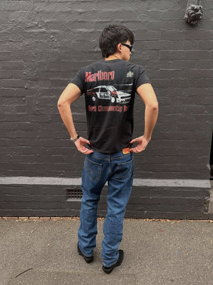 Lifestyle shot of a man in a black graphic t-shirt and jeans.